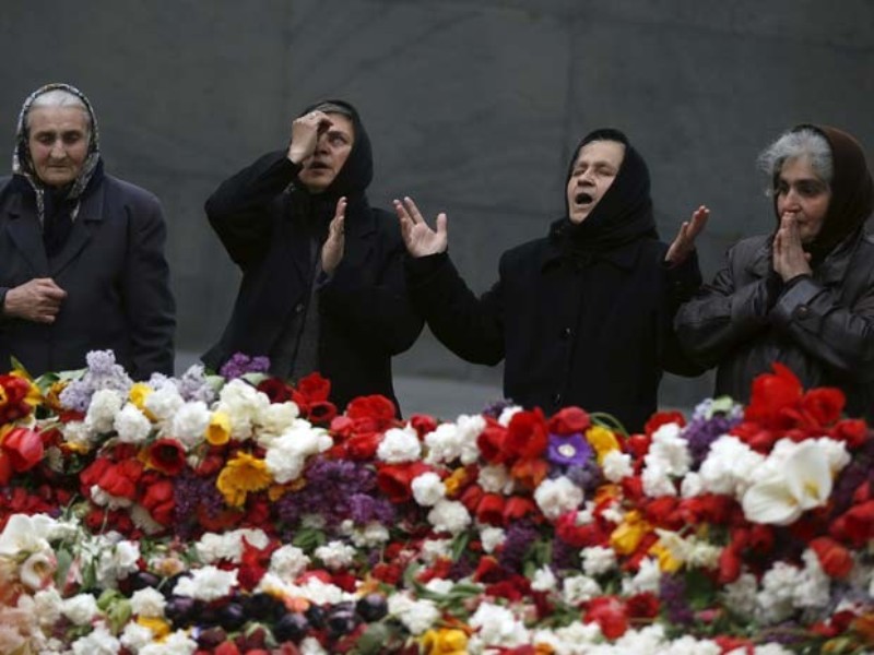 Foto: Reuters/David Mdzinarishvili - Mulheres arménias rezam junto de memorial das vítimas do massacre ocorrido durante a Primeira Guerra Mundial 