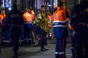 Foto LUSA - Um sobrevivente do atentado ao Bataclan Café, em Paris, a receber apoio das forças de emergência